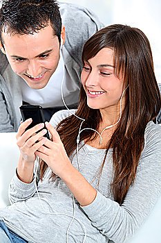 Young couple listening to music with mobile phone