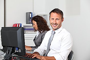 Smiling businessman working on computer