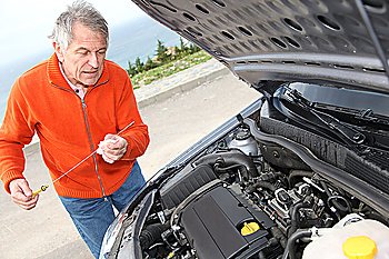 Senior man checking car motor levels