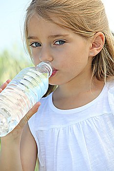 Blonde cute little girl drinking water