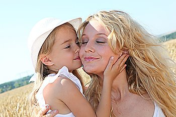 Little girl kissing her mom on the cheek