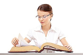 Business girl thumbs through the thick book at a table, isolated