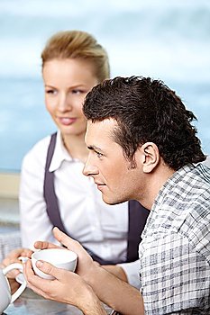 The attractive man and the girl drink coffee 