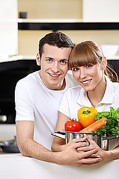 Young couple with capacity with vegetables in the foreground 
