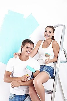 Laughing couple with a brush or roller for painting walls