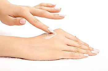 The female hand puts a cream on other hand, isolated