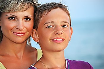 smiling boy and young woman on beach in evening