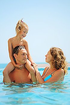 happy family in pool. Daughter sits on fathers shoulder