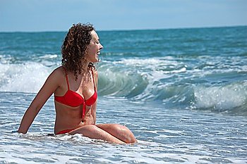 beauty girl sits in sea surf