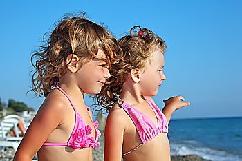 two pretty little girls on beach near sea, Looking afar