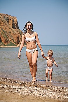 Young woman with the child ashore of sea