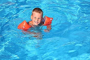 The boy floats in pool