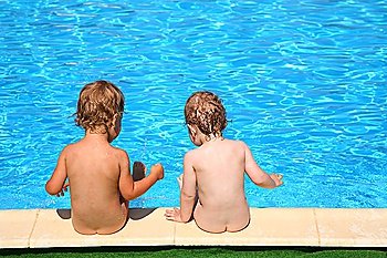 Two children sit at pool