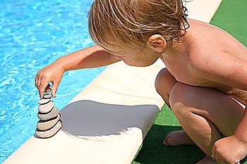 The child builds a figure of stones about water