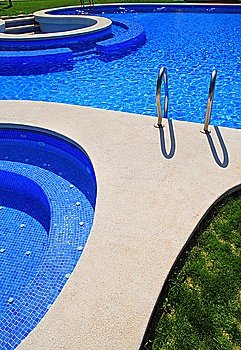 blue tiles swimming pool with green grass garden around