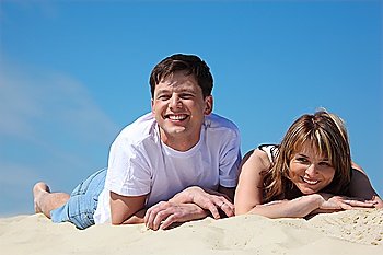 young pair lies on sand