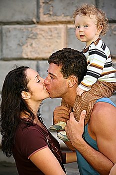 man with the child kisses the woman
