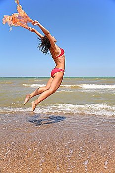 The woman jumps with a scarf.