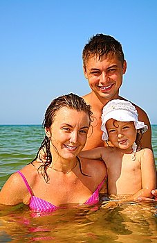 Family with little girl pose in sea
