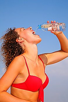 Girl in red bikini drinking water