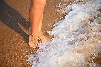 Legs on wave on sand