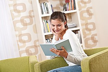 Students - Happy teenager with book sitting on armchair in lounge