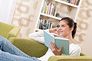 Students - Happy teenager with book sitting on armchair in lounge
