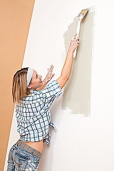 Home improvement: Woman painting wall with paint brush