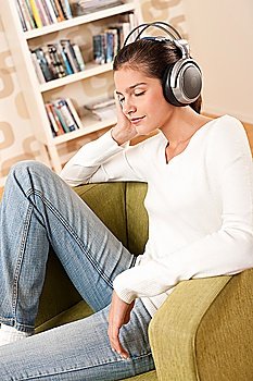 Students - Happy female teenager with headphones listening to music in modern lounge