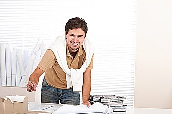 Successful architect man working at office with plans and architectural model