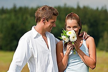 Romantic couple with flower in spring on sunny day