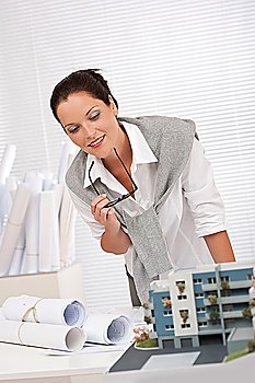 Female architect working at office with architectural model
