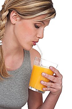 Woman drinking orange juice on white background