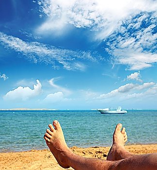 man foots on beach near turquoise sea