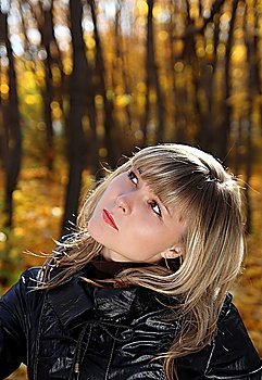 portrait of pretty girl looking upward in autumn park