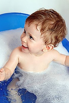 happy smiling baby bath in blue bathtub