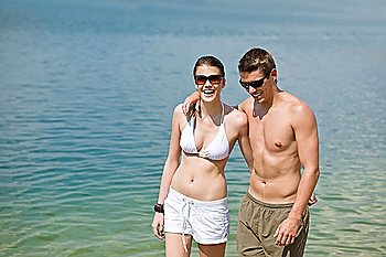 Happy couple in swimwear at sea enjoy summer sun