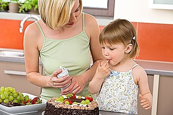 Mother and child with chocolate cake in modern kitchen