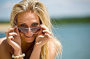 Blond woman with sunglasses enjoy sunny day on seashore