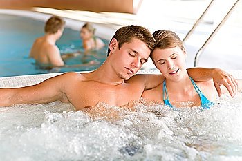 Swimming pool - young attractive couple relax in hot tub