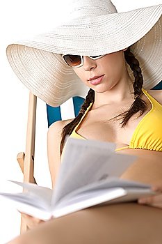 Beach - Young woman in bikini relax with book sunbathing on deckchair