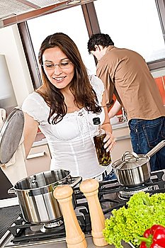 Young couple cook in modern kitchen, man helping with dishes