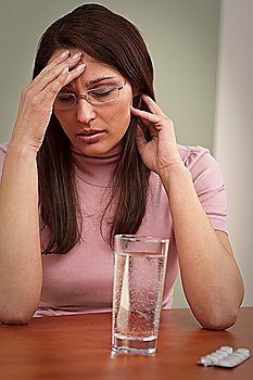 Businesswoman with headache take pill at modern office