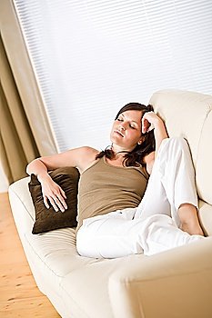 Beautiful woman lying down sleeping on sofa in living room