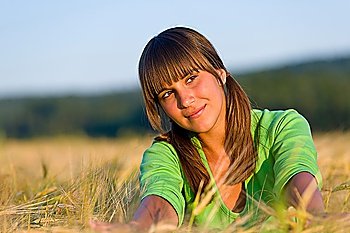 Portrait of happy woman in sunset corn field enjoying summer sun