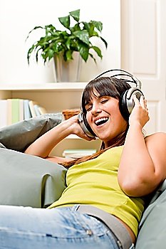 Teenager girl relax home - happy listen to music with headphones singing
