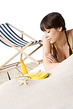 Beach - Attractive woman in bikini sunbathing, deck-chair in in background