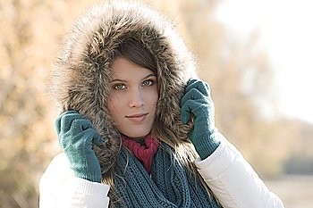 Winter fashion - woman with fur hood and gloves outside, desaturated colors