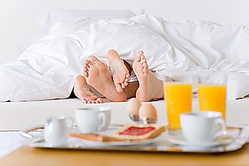 Luxury hotel honeymoon breakfast - couple in white bed together