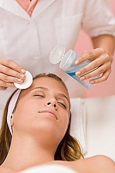 Skin care - woman cleaning face by beautician